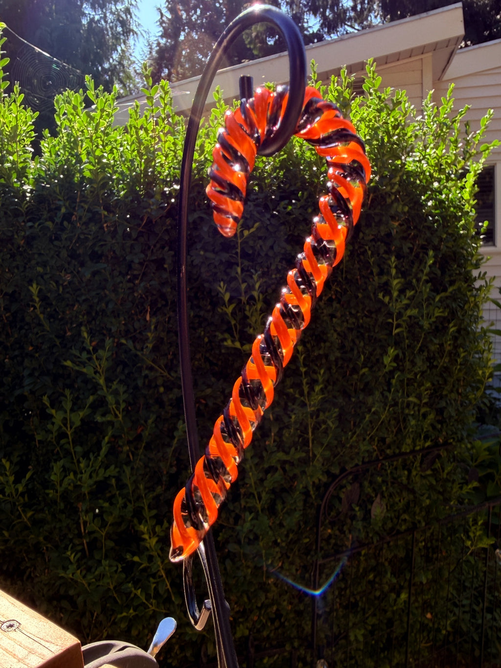 Handmade orange and dark glass candy cane ornament