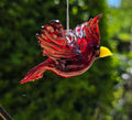 Handmade ruby-red glass cardinal ornament with raised wings, a tall crest and yellow beak