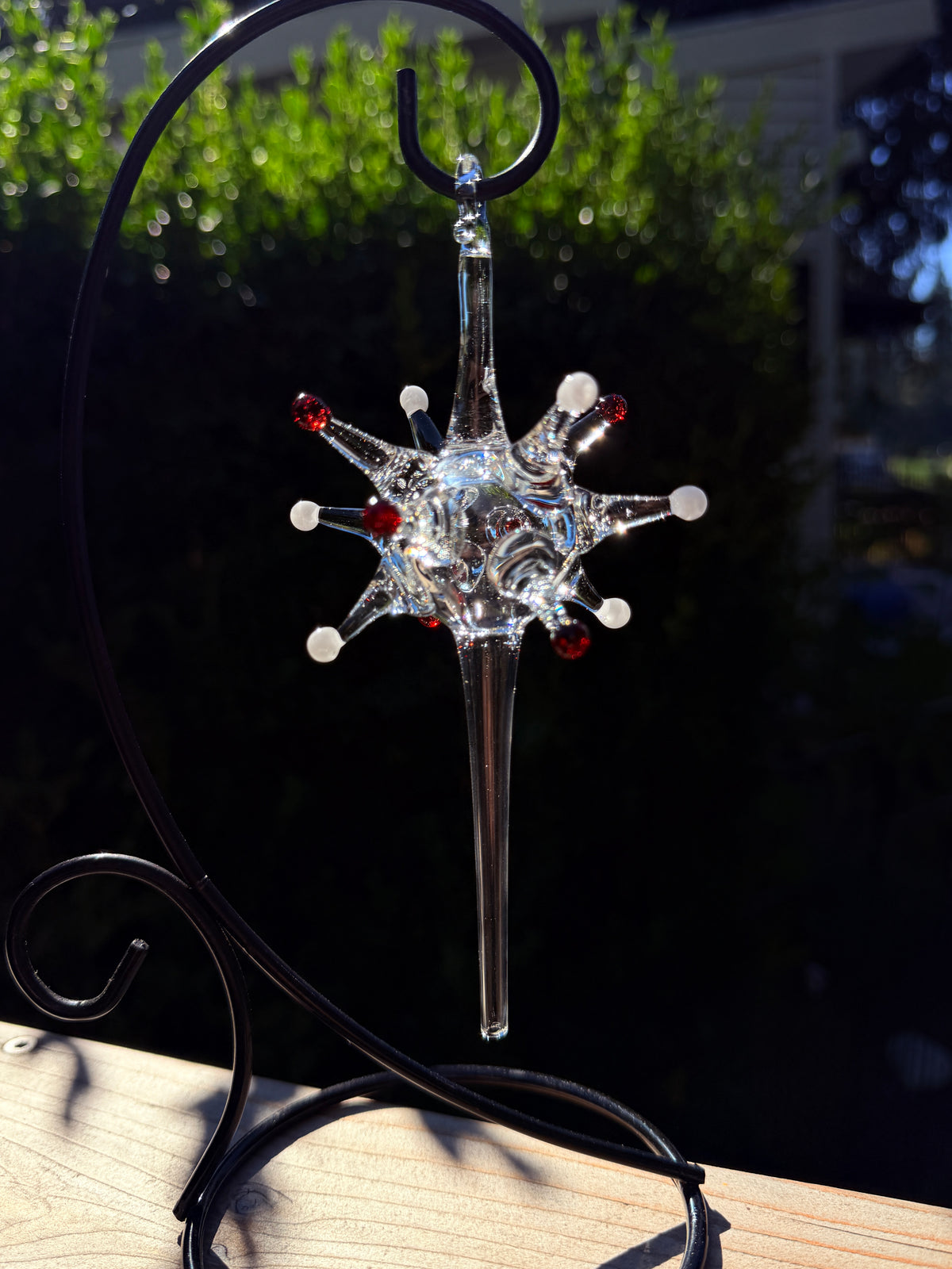 Starburst glass ornament with red and white color dots